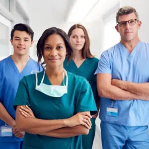 A group of medical professionals in scrubs standing in a hospital hallway
